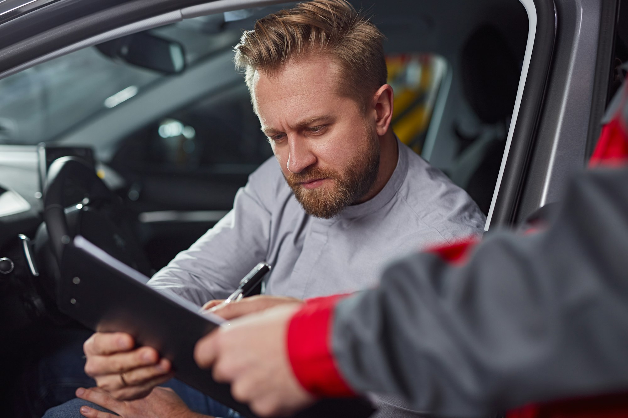 Car mechanic and client with report on clipboard